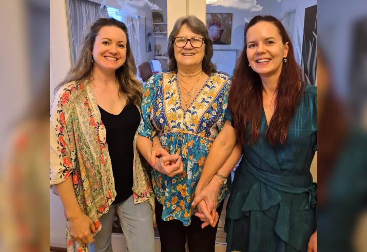 Mum Jenny pictured middle, holding hands with daughters Michelle and Melissa either side of her.