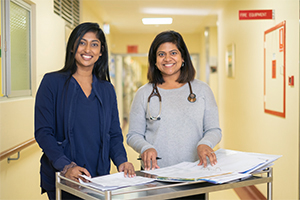 Two female health professionals stand in a hospital corridor
