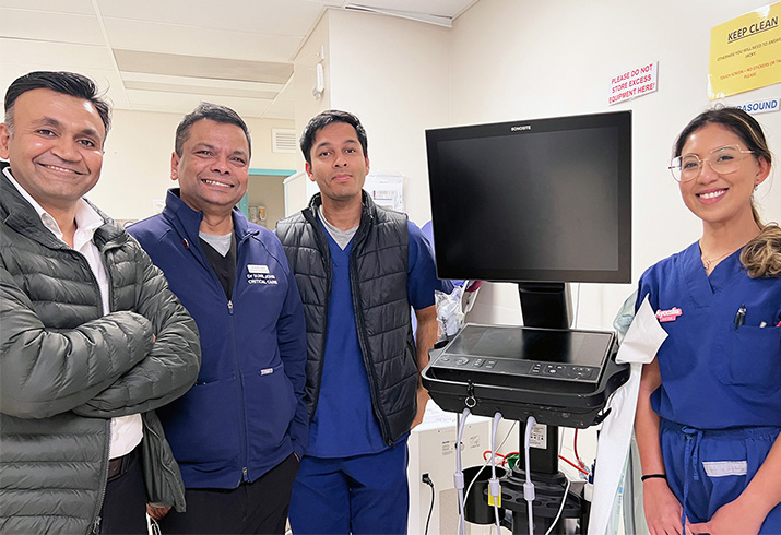 A group of doctors stand beside an item of medical equipment